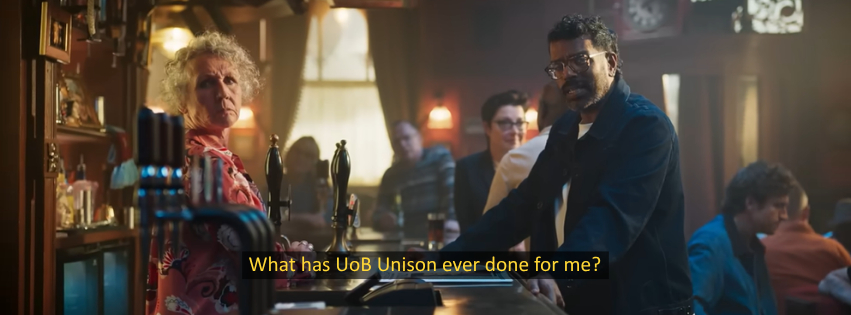 A screenshot from the BBC's recent ad 'what has the BBC ever done for me', where the broadcaster encourages the viewer to pay their TV license. The scene is comedian Romesh Ranganathan talking to the camera in a pub, surrounded by other regular BBC faces like presenter Sue Perkins and radio 1 host Greg James. We have parodied the advert - the subtitles here instead say 'What has UOB unison ever done for me?'